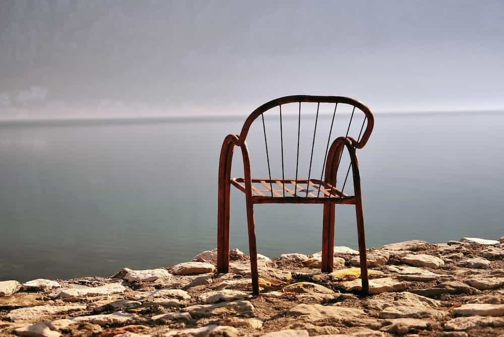 Cadira de metall sola davant el mar
