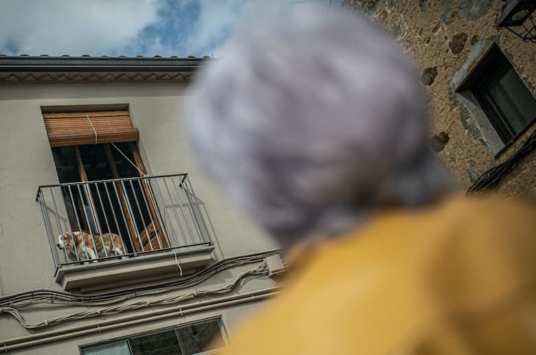 Dona mirant a un gos en que està en un balcó